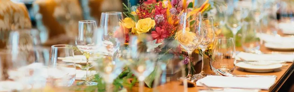 colorful spring flower table center piece white napkins and three sets of beverage glassware