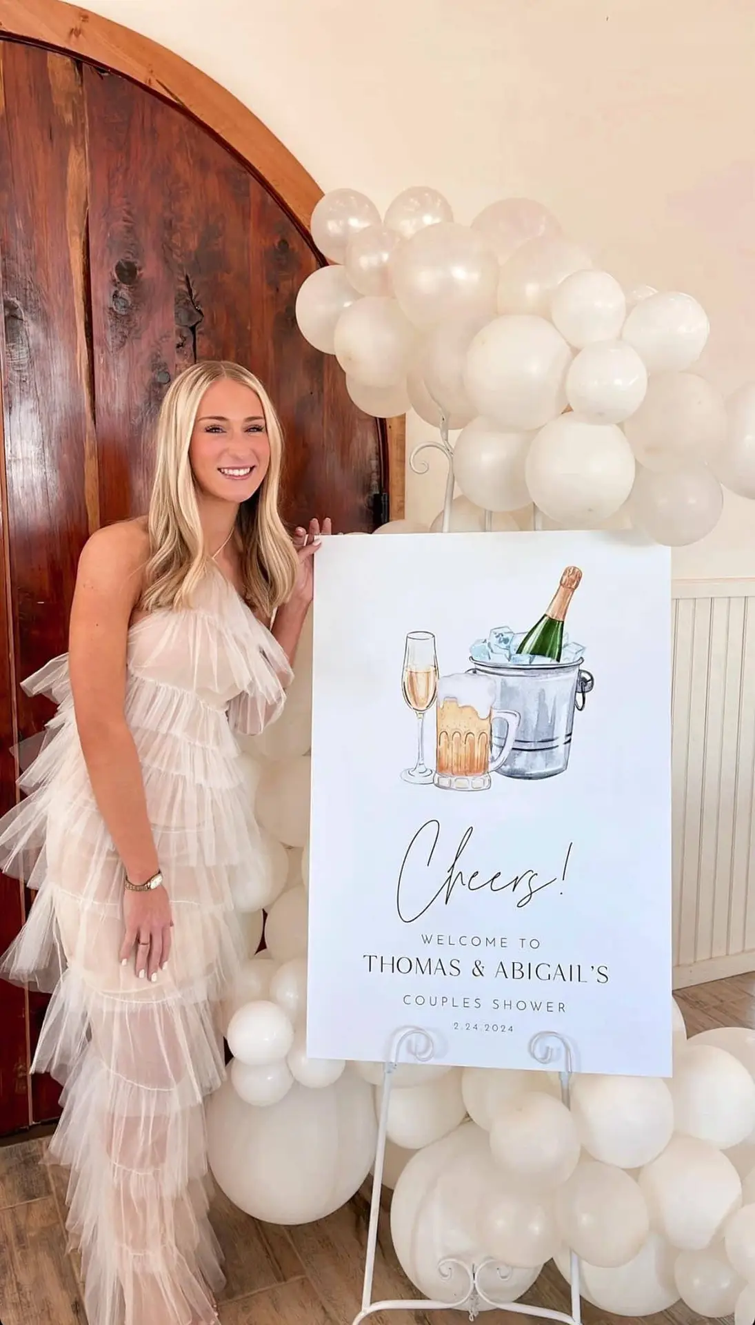 bride with poster and white balloon stand