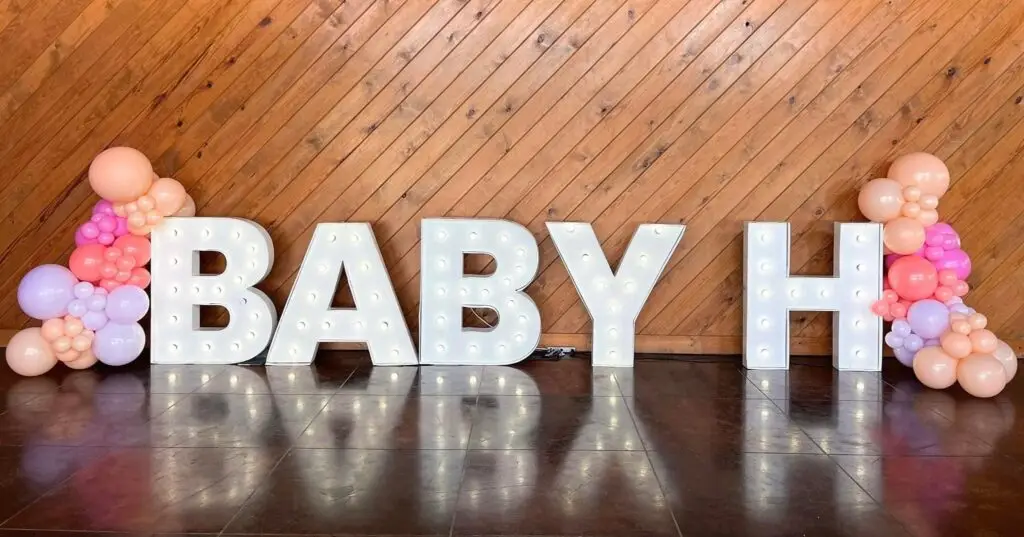 Large "BABY H" marquee letters with soft lights and pastel balloons create a festive, elegant vibe at El Cerrito event venue.