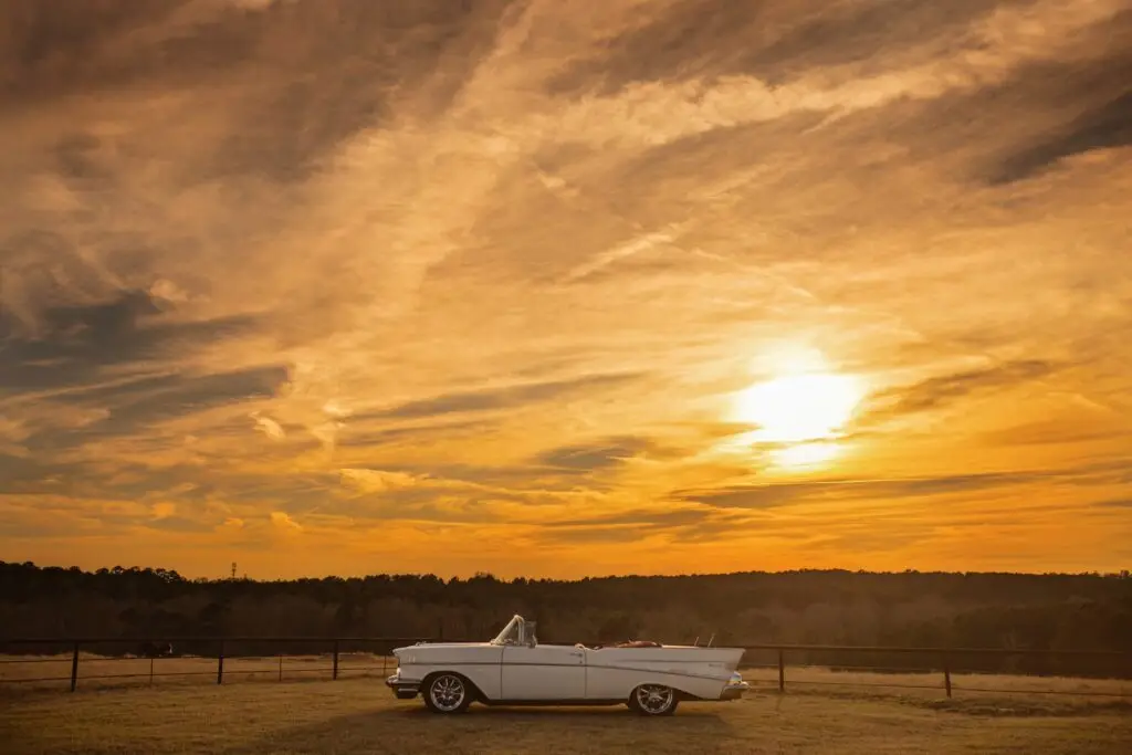A stylish white convertible on lush grass at El Cerrito, set against a romantic sunset—perfect for unforgettable wedding celebrations.