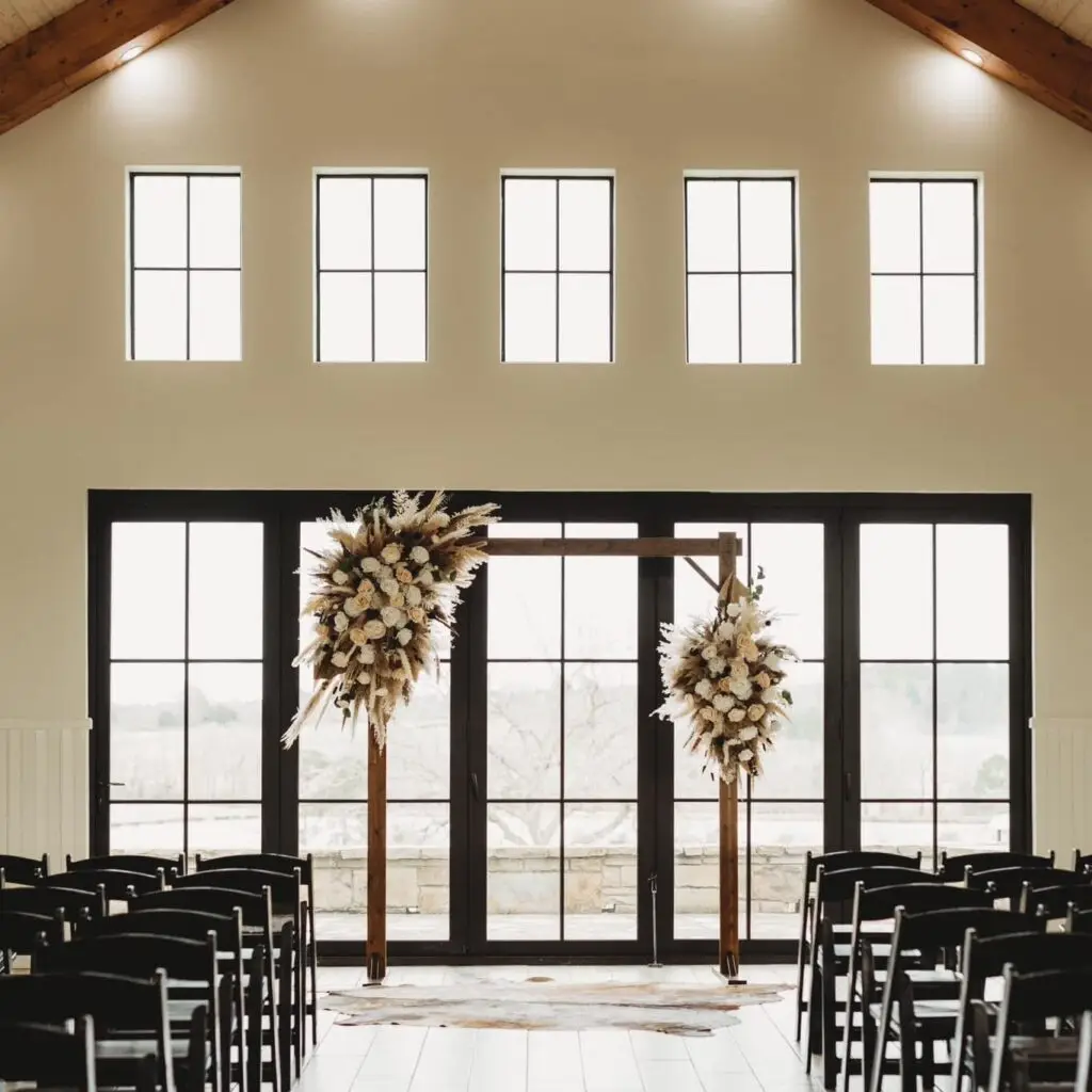 El Cerrito wedding venue with black chairs, a wooden arch with dried florals, and bright windows—perfect for modern celebrations.